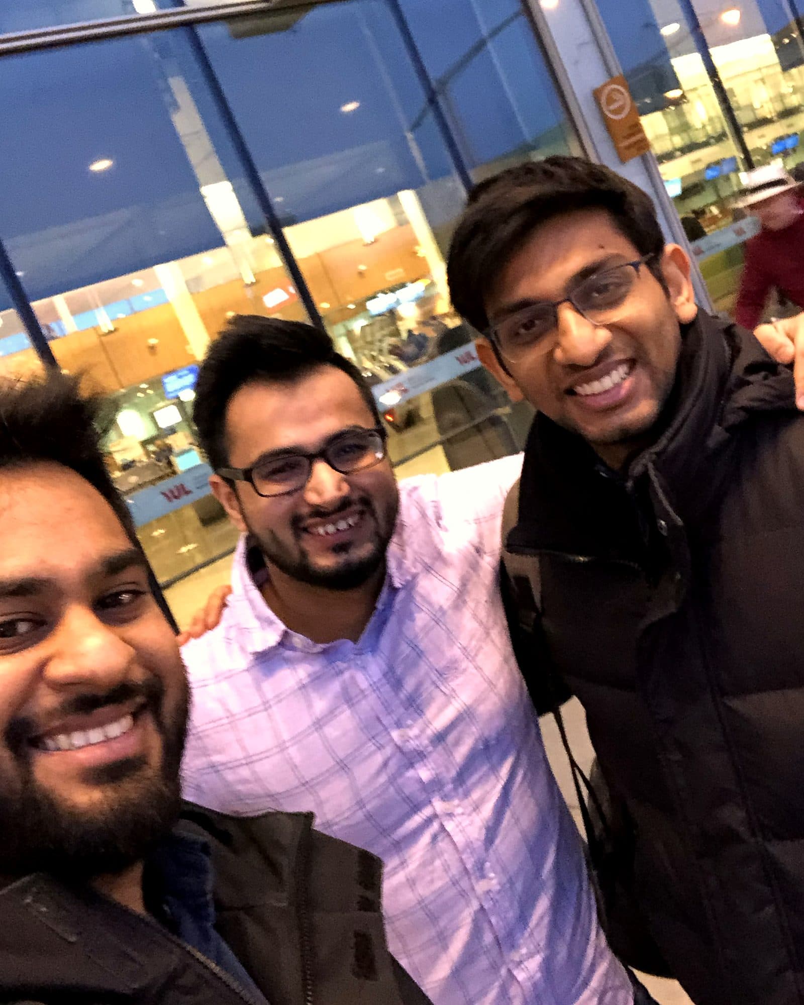 Three friends outside an airport terminal at night
