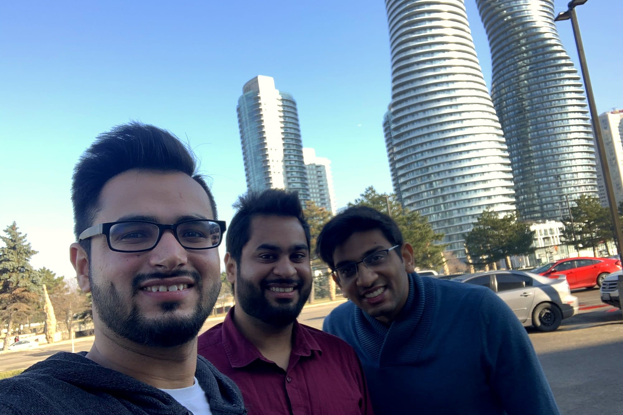 Three friends in front of a city skyline on a trip